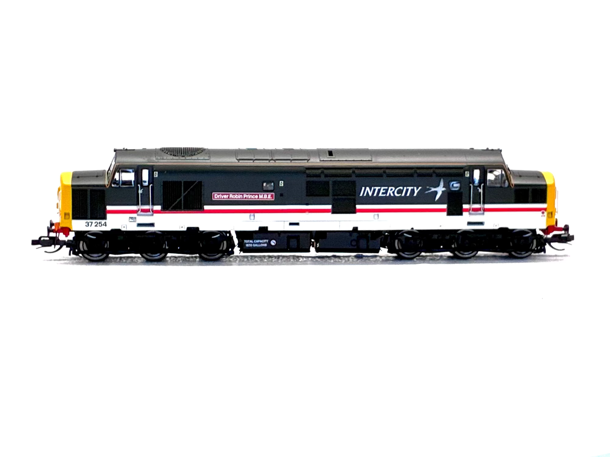 A model train locomotive in InterCity livery, featuring a black upper body, white lower body, red stripe, and yellow front and back buffers, shown on a plain white background.