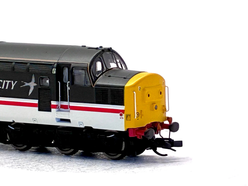 A close-up of a model train locomotive on a white background, featuring a black, white, and red livery with a bright yellow front cab.