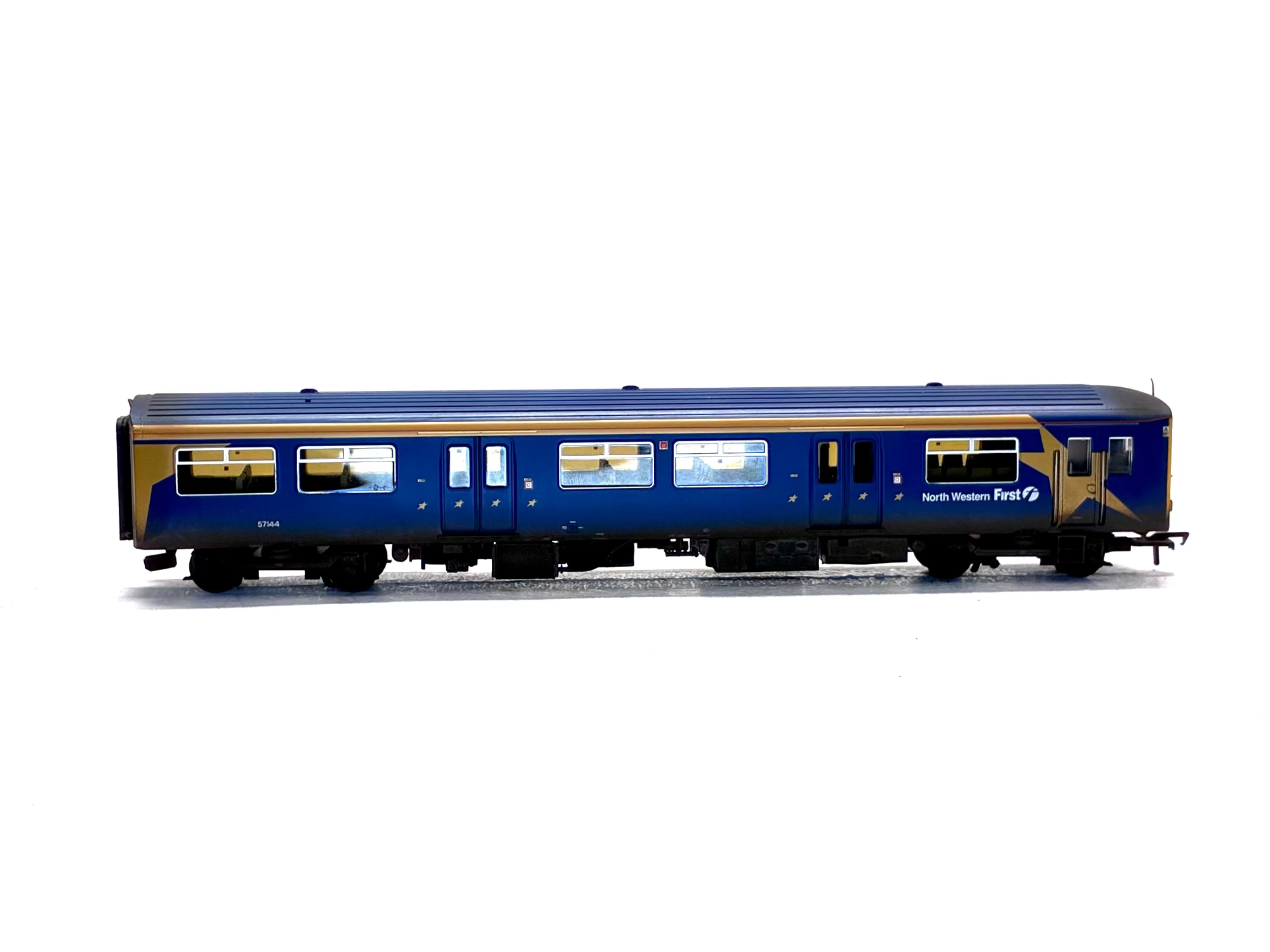 A detailed model of a North Western First passenger carriage in blue and gold livery, shown from a side profile on a white background.