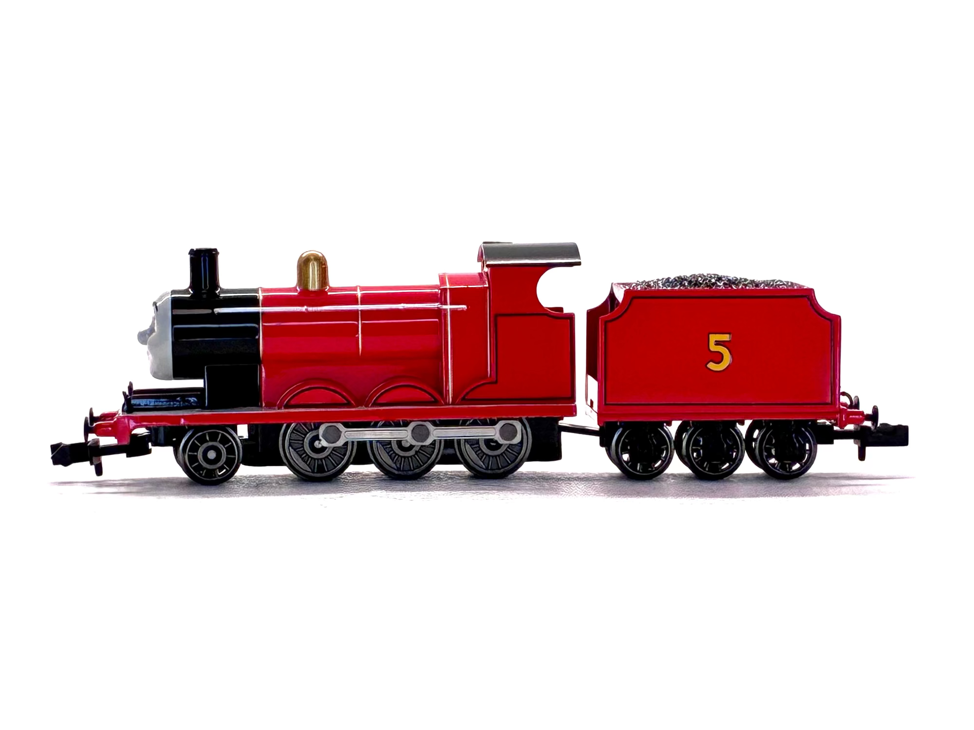 James model train locomotive pulling a matching red coal car, photographed from the side against a plain white background.