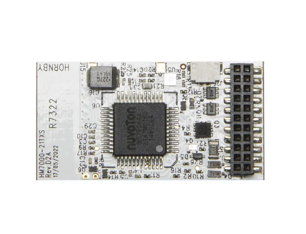A white electronic circuit board featuring a central black microcontroller chip, various surface-mount electronic components, and a black multi-pin connector on the right side.