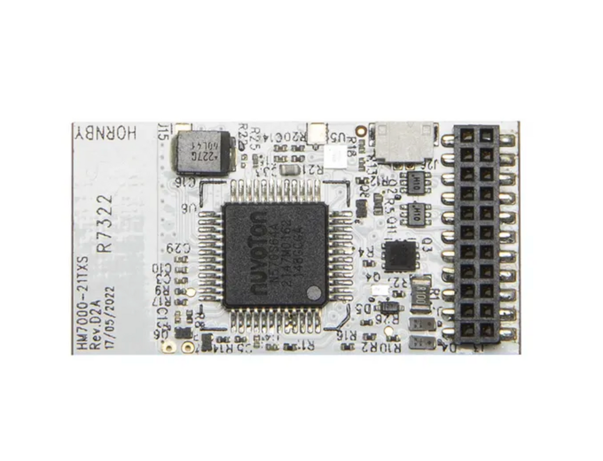 A white electronic circuit board featuring a central black microcontroller chip, various surface-mount electronic components, and a black multi-pin connector on the right side.