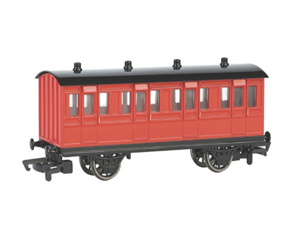 A red and black model passenger train carriage on a plain white background.