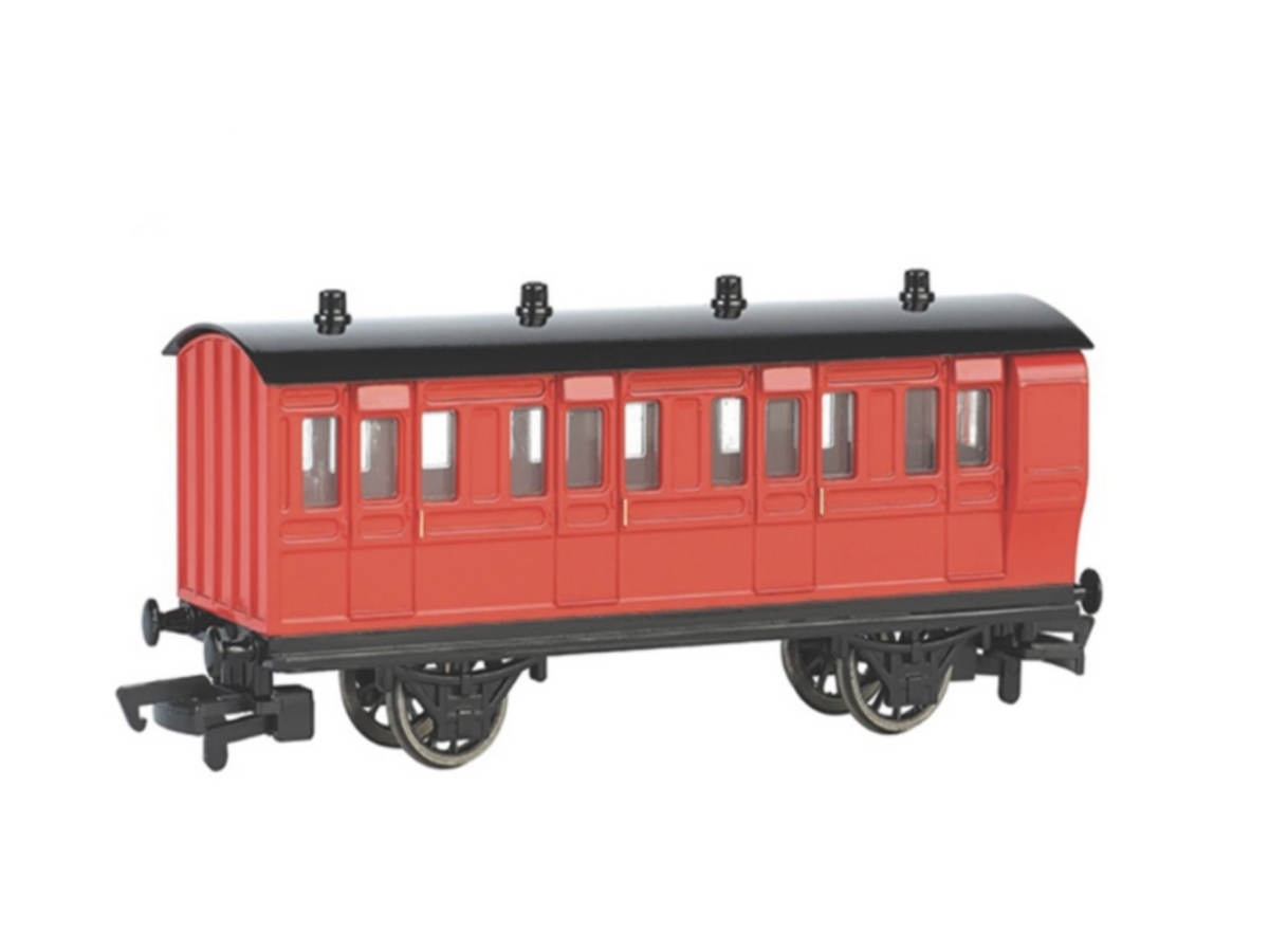 A red and black model train red break coach a plain white background.