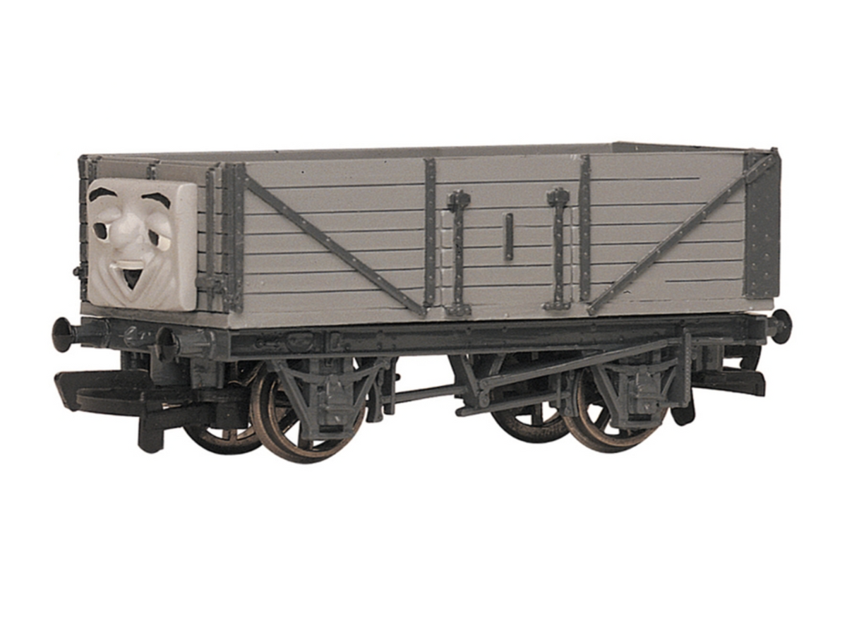 A Thomas the Tank Engine themed model Troublesome truck, featuring a gray body with a face on the front end, shown against a plain white background.