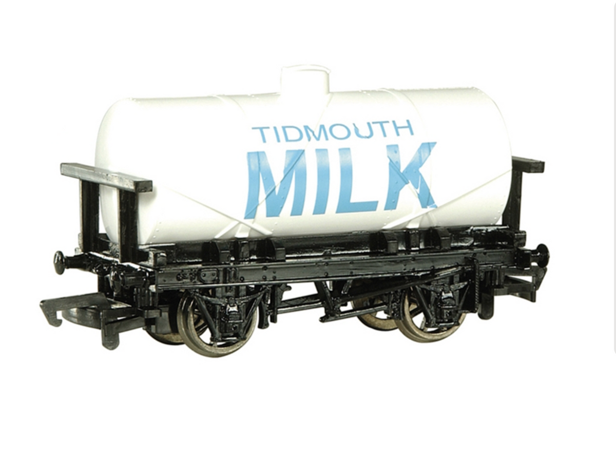 A model tanker cart on a white background, featuring a white cylindrical tank with blue 'TIDMOUTH MILK' lettering and a detailed black undercarriage with wheels.